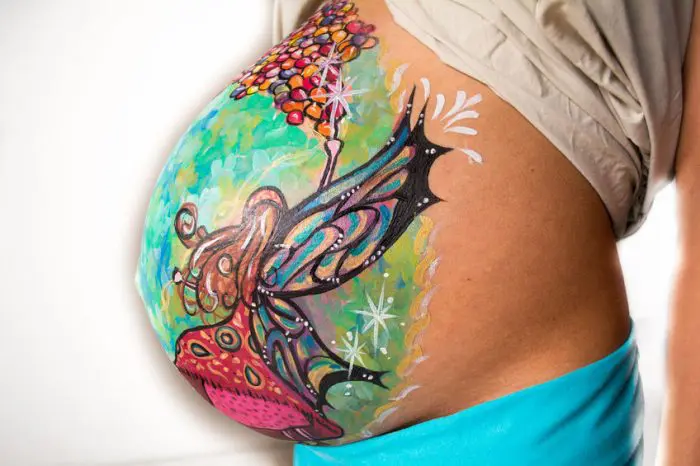Barriga embarazada pintada mariposa