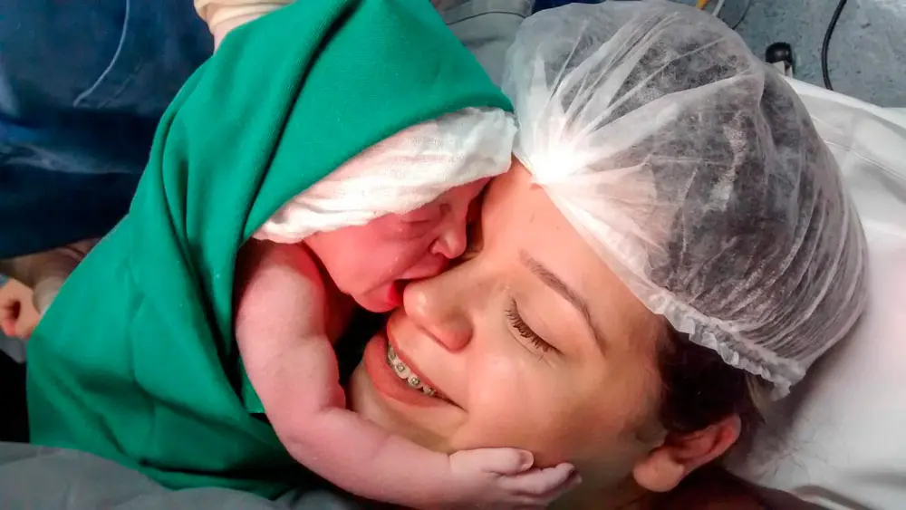 Bebé que abraza a su mamá nada más nacer