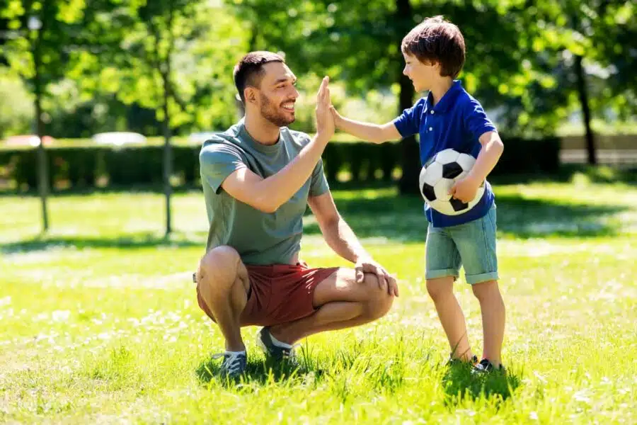 padre jugando futbol hijo parque